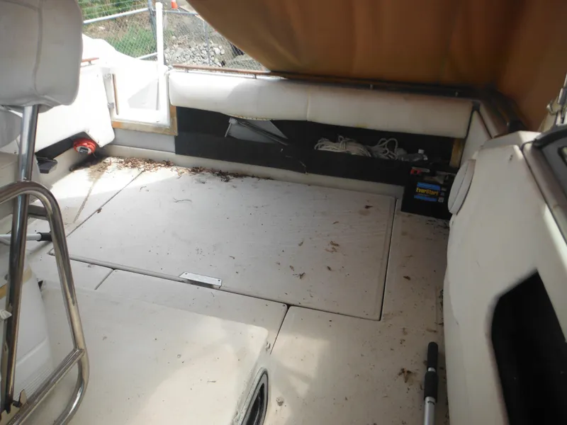 Slide: The Image of Interior of 1988 Sea Ray 268 Sundancer boat with white seating and storage compartments. - 37