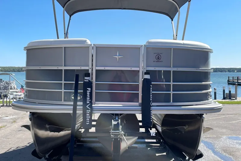 Slide: The Image of 2023 Berkshire 24 UL CTS pontoon boat on a trailer by the lake. - 2