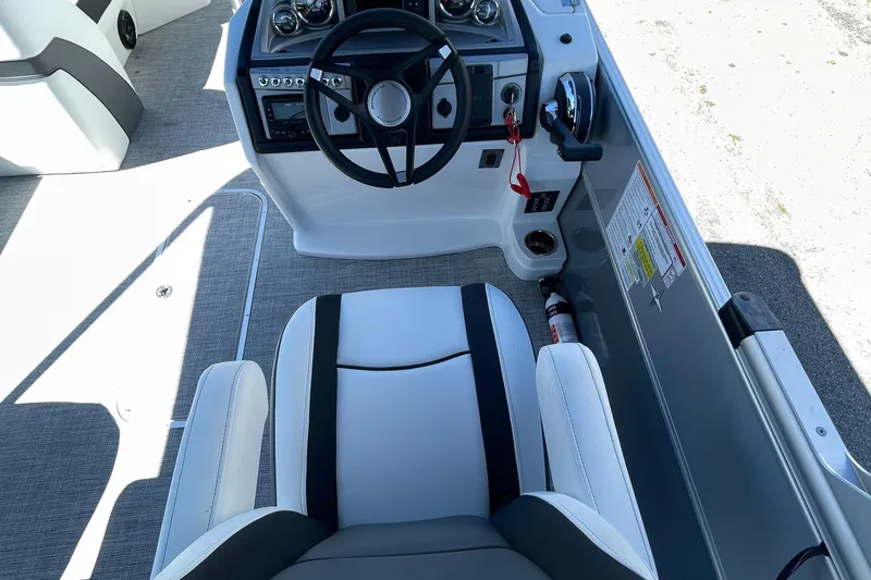Slide: The Image of 2023 Berkshire 24 UL CTS boat cockpit with steering wheel and captain's chair. - 22