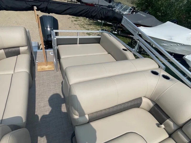 Slide: The Image of 2024 Sun Tracker Party Barge 22 RF XP3 interior with beige seating and cup holders. - 10