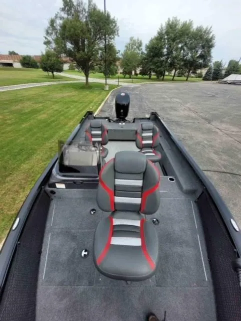 Slide: The Image of 2023 Ranger VS1882SC Reata boat with gray and red seating, parked on pavement. - 5