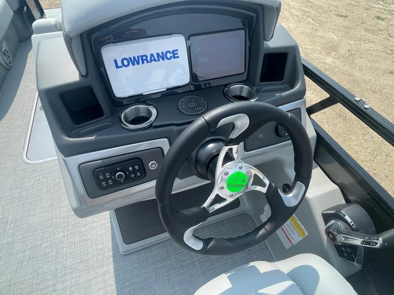 Slide: The Image of 2024 Regency 250 DL3 boat dashboard with Lowrance display and steering wheel. - 15