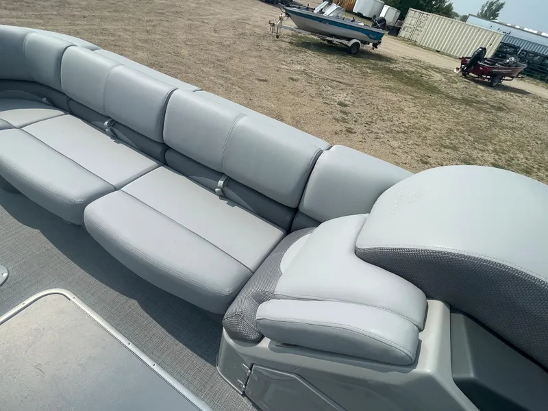 Slide: The Image of 2024 Regency 250 DL3 pontoon boat with spacious gray seating. - 20