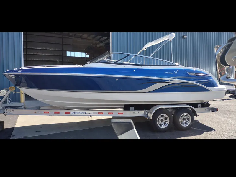 The Image of 2024 Formula 240 BR boat on a trailer outside a blue warehouse. - 0