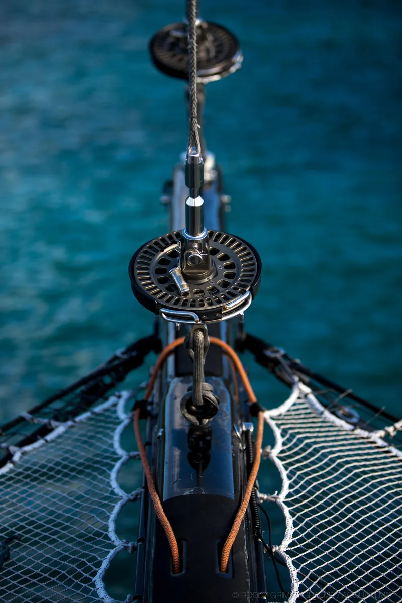 Slide: The Image of Gunboat 60 sailboat bow with netting, 2015 model, over clear blue water. - 11