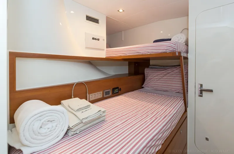 Slide: The Image of Bunk beds in 2015 Gunboat 60 yacht cabin with striped bedding and folded towels. - 28