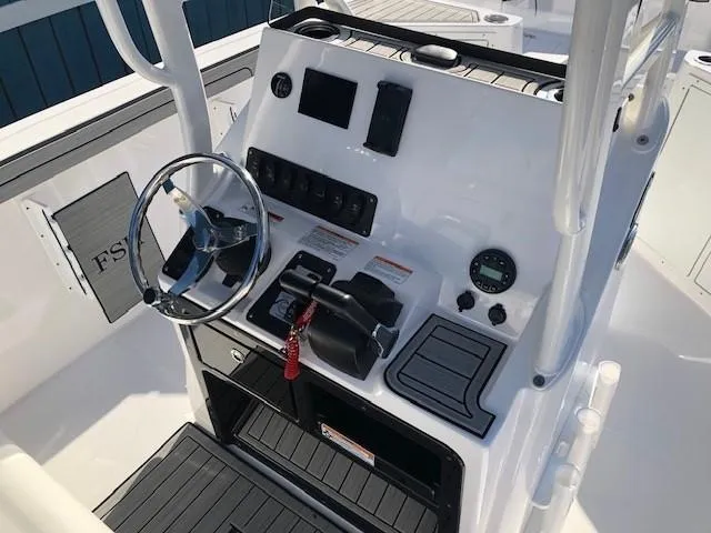 Slide: The Image of 2024 Yamaha Boats 220 FSH Sport console with steering wheel and controls. - 11