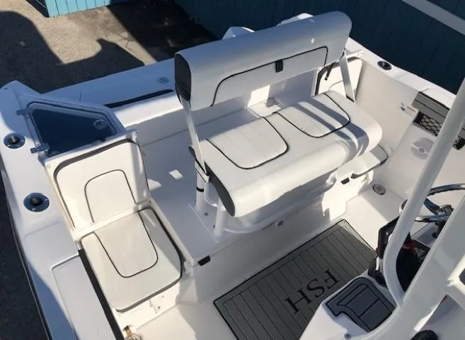 Slide: The Image of 2024 Yamaha Boats 220 FSH Sport interior seating, featuring white cushioned seats and deck mat. - 13