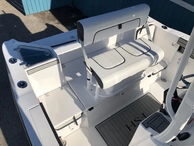 Slide: The Image of 2024 Yamaha Boats 220 FSH Sport interior with white seating and deck. - 14