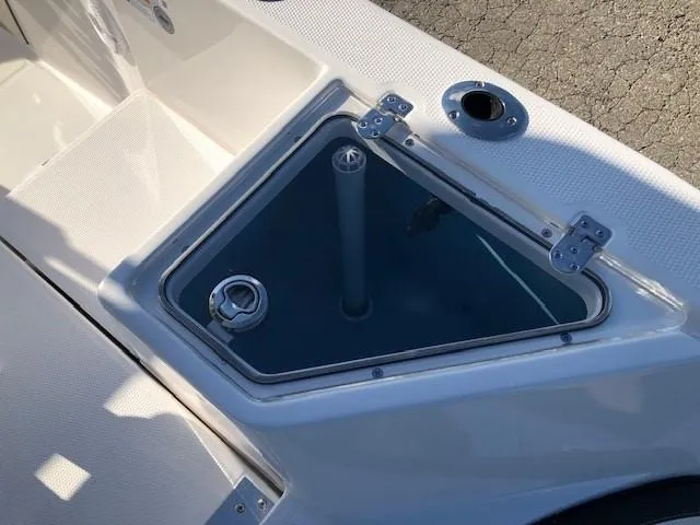 Slide: The Image of 2024 Yamaha Boats 220 FSH Sport storage compartment with open hatch. - 16