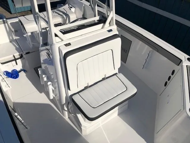 Slide: The Image of 2024 Yamaha Boats 220 FSH Sport interior seating, white and black upholstery, modern design. - 8