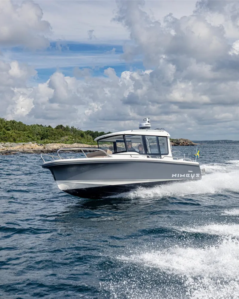 Slide: The Image of 2024 Nimbus C8 boat cruising on open water under a cloudy sky. - 13