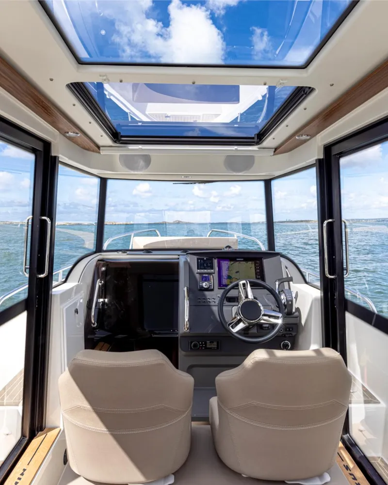 Slide: The Image of Interior view of 2024 Nimbus C8 boat cockpit with panoramic windows and skylight. - 23