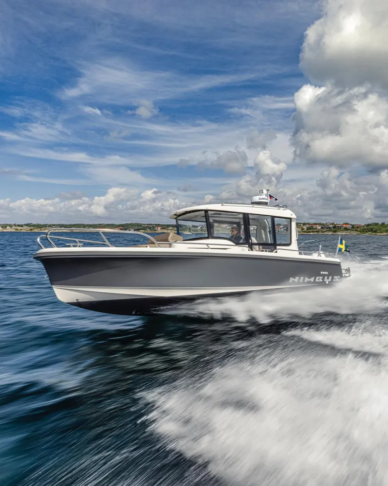 Slide: The Image of 2024 Nimbus C8 boat cruising on open water under a partly cloudy sky. - 12