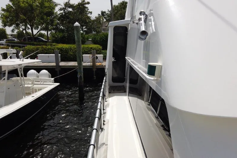 Slide: The Image of 1999 Viking Cockpit Motoryacht docked, side view with water and nearby boats. - 11