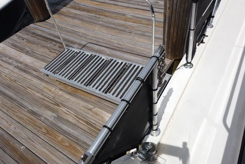 Slide: The Image of Boarding platform on 1999 Viking Cockpit Motoryacht with wooden dock background. - 14