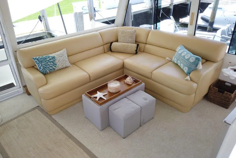 Slide: The Image of Luxurious beige seating area on 1999 Viking Cockpit Motoryacht with decorative pillows and ottomans. - 18