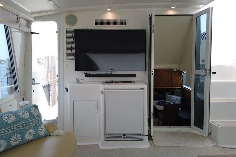 Slide: The Image of 1999 Viking Cockpit Motoryacht interior with TV, seating, and open door to cabin. - 19