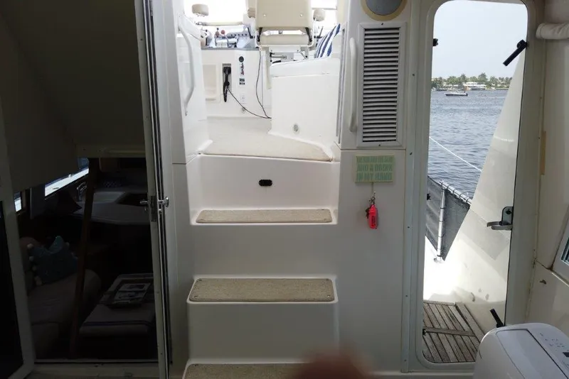 Slide: The Image of 1999 Viking Cockpit Motoryacht interior with steps leading to the deck, overlooking the water. - 21