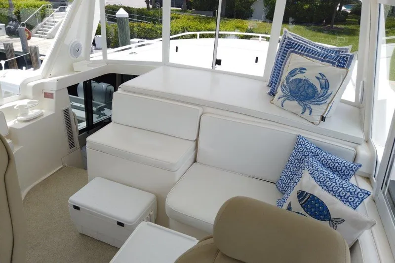 Slide: The Image of 1999 Viking Cockpit Motoryacht interior with white seating and nautical-themed cushions. - 22