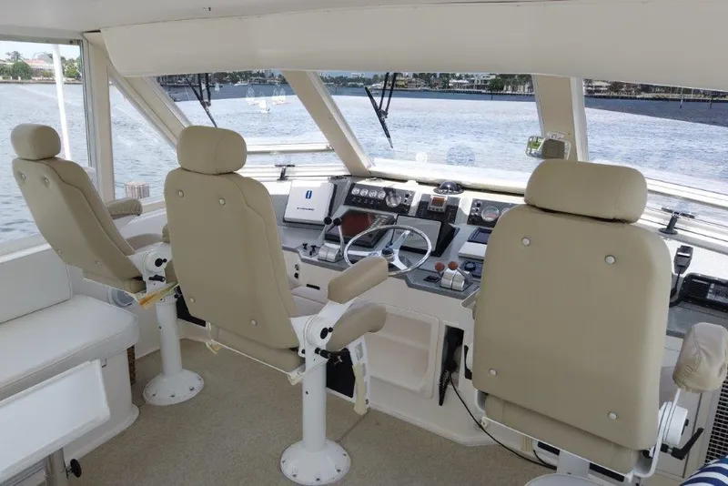 Slide: The Image of 1999 Viking Cockpit Motoryacht helm with beige seats and navigation controls. - 23