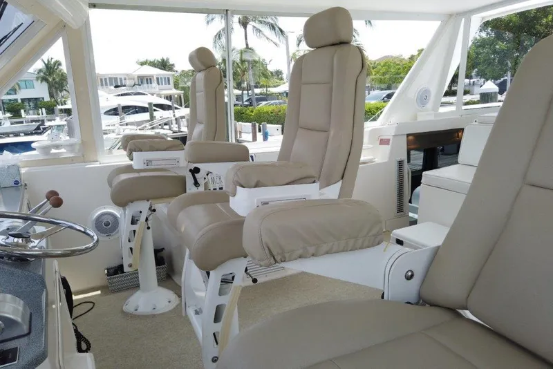 Slide: The Image of 1999 Viking Cockpit Motoryacht interior with beige captain chairs and panoramic windows. - 24