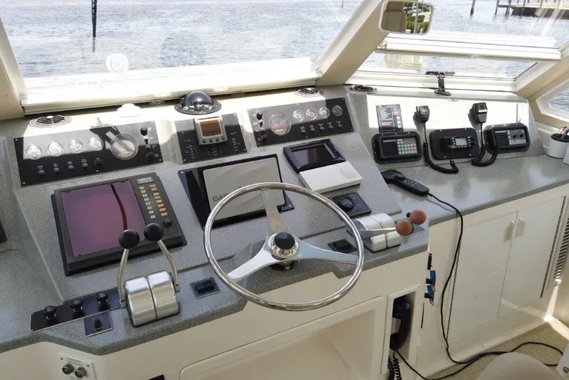 Slide: The Image of Cockpit of 1999 Viking Motoryacht with navigation controls and communication devices. - 26