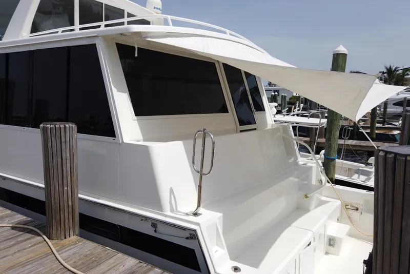 Slide: The Image of 1999 Viking Cockpit Motoryacht docked, featuring sleek white exterior and shaded cockpit area. - 3
