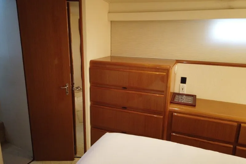 Slide: The Image of 1999 Viking Cockpit Motoryacht interior with wooden cabinets and open door to bathroom. - 38