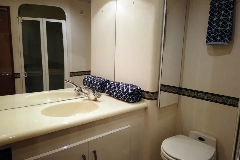 Slide: The Image of Bathroom interior of 1999 Viking Cockpit Motoryacht with sink, mirror, and toilet. - 39