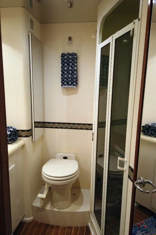 Slide: The Image of 1999 Viking Cockpit Motoryacht bathroom with toilet, shower, and nautical decor. - 40