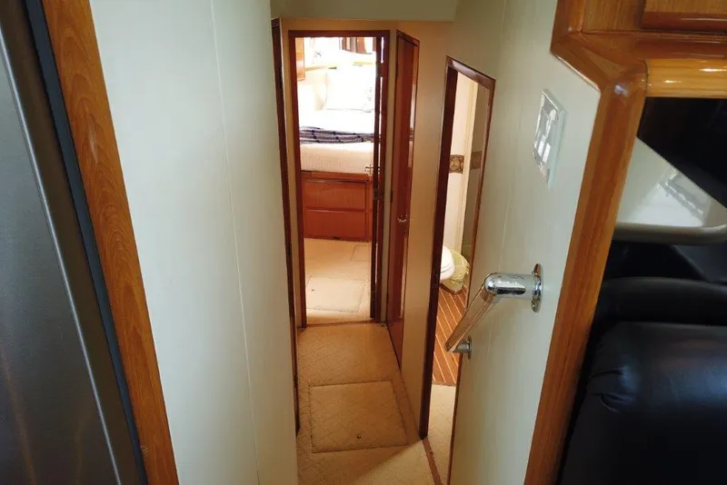 Slide: The Image of Interior hallway of 1999 Viking Cockpit Motoryacht with wood accents and carpeted floor. - 41