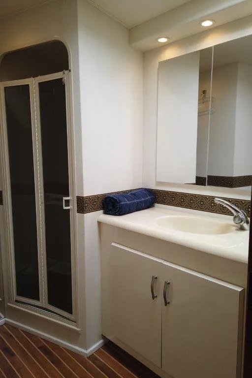 Slide: The Image of Bathroom interior of 1999 Viking Cockpit Motoryacht with shower, vanity, and wood flooring. - 45