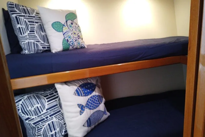 Slide: The Image of Bunk beds with nautical-themed pillows in a 1999 Viking Cockpit Motoryacht cabin. - 46