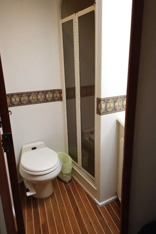 Slide: The Image of 1999 Viking Cockpit Motoryacht bathroom with shower, toilet, and wood-patterned flooring. - 47