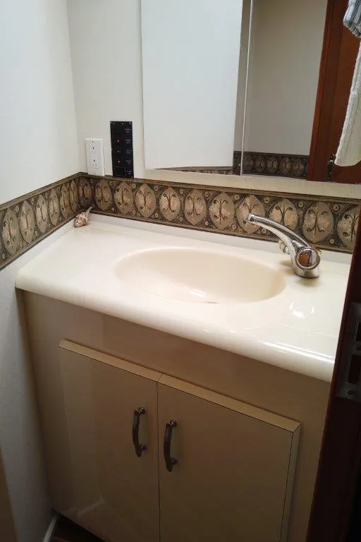 Slide: The Image of 1999 Viking Cockpit Motoryacht bathroom sink with decorative backsplash and mirror. - 48