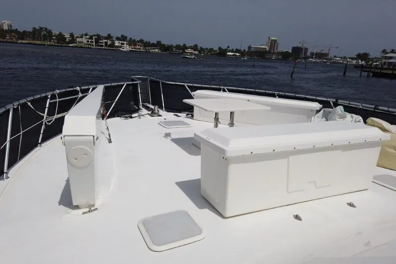 Slide: The Image of 1999 Viking Cockpit Motoryacht deck with seating, overlooking calm waters and distant shoreline. - 7
