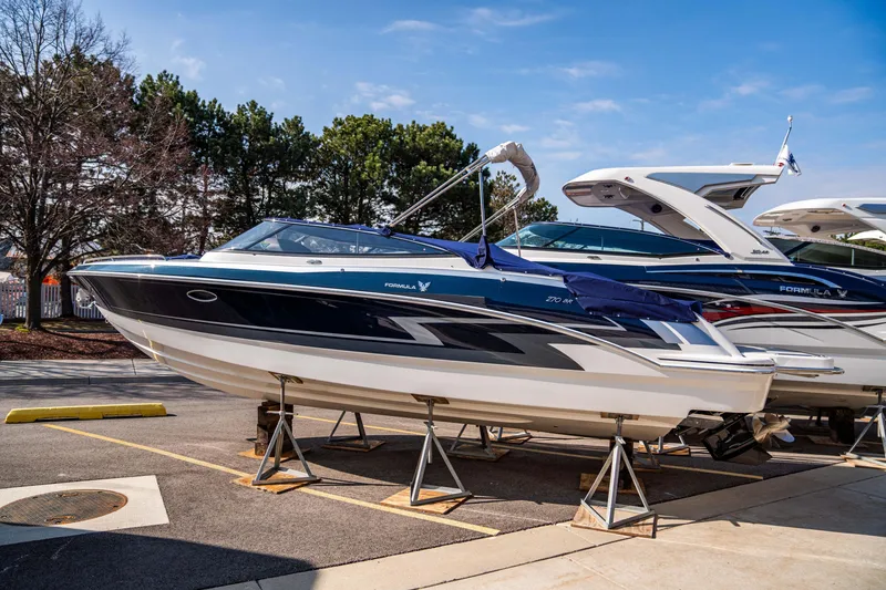 Slide: The Image of 2024 Formula 270 Bowrider boat on display, elevated on stands, outdoors. - 19