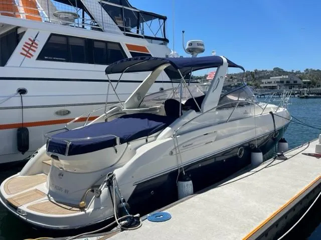 Slide: The Image of 2005 Cranchi 33 Express yacht docked at marina, featuring sleek design and blue canopy. - 1
