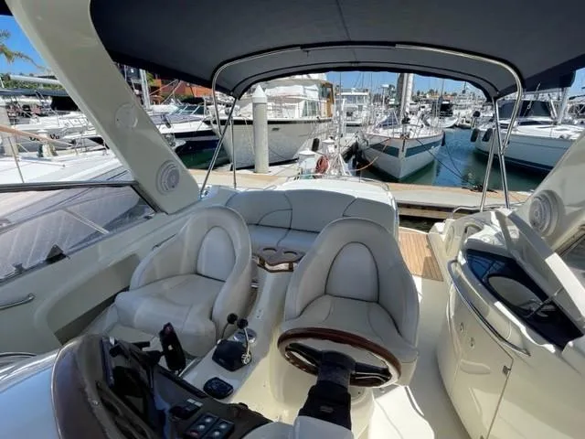 Slide: The Image of 2005 Cranchi 33 Express yacht interior with helm, seating, and marina view. - 16