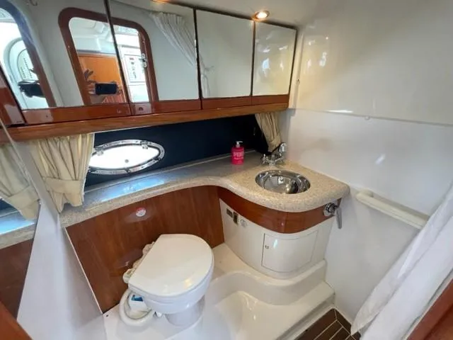 Slide: The Image of 2005 Cranchi 33 Express yacht bathroom with sink, toilet, and mirrored cabinets. - 5
