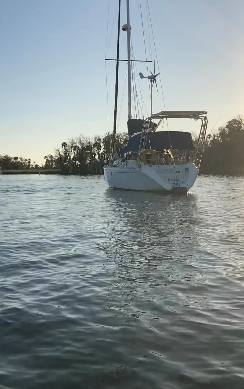 Slide: The Image of Beneteau M38 1990 sailboat anchored in calm waters at sunset. - 1