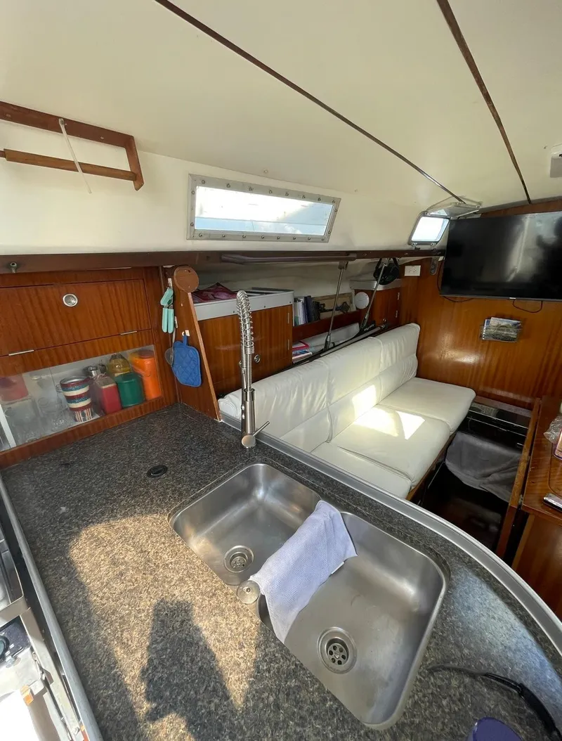 Slide: The Image of Interior of 1990 Beneteau M38 sailboat with kitchen and seating area. - 15