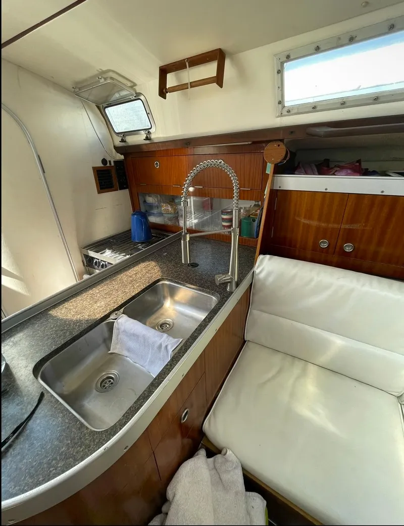 Slide: The Image of Interior of 1990 Beneteau M38 sailboat with kitchen sink and seating area. - 16