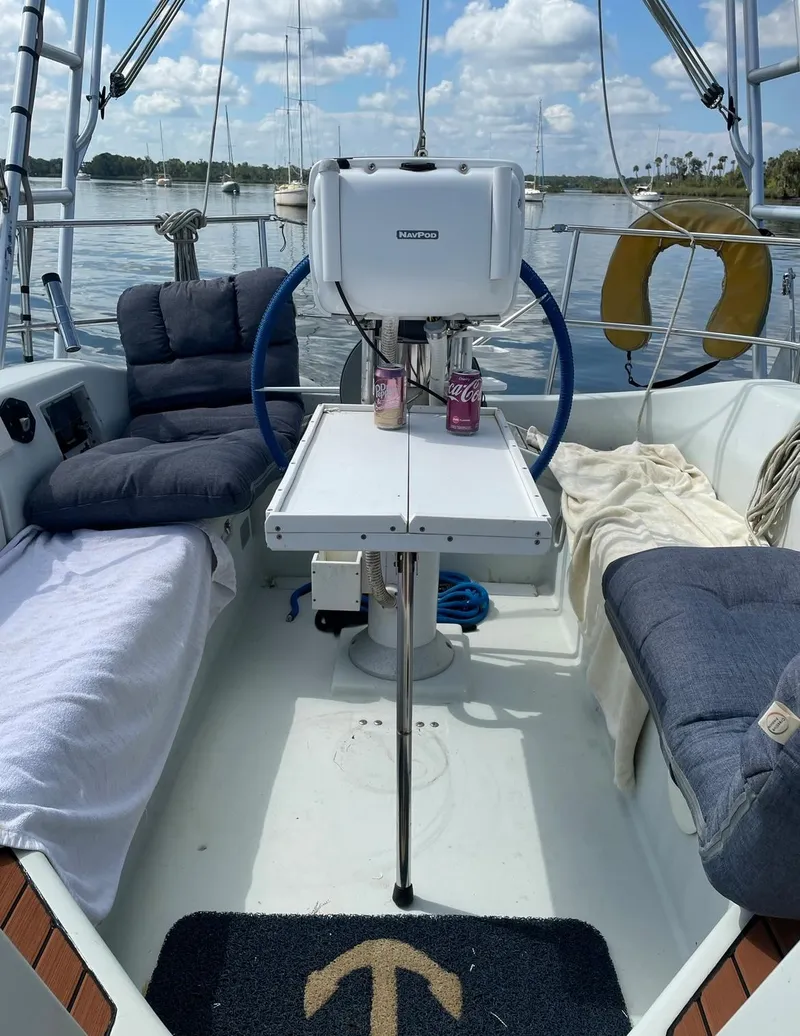 Slide: The Image of Beneteau M38 1990 sailboat cockpit with table, cushions, and scenic water view. - 5