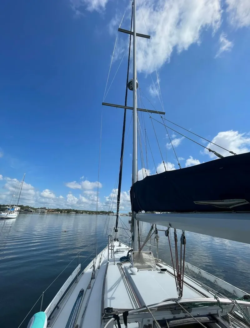 Slide: The Image of Beneteau M38 1990 sailboat on calm water under blue sky. - 6