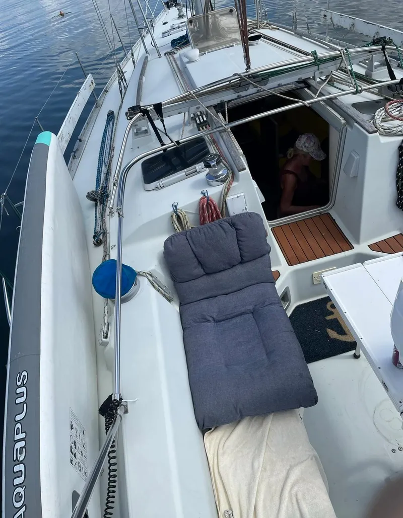 Slide: The Image of 1990 Beneteau M38 sailboat deck with lounge chair and open cabin. - 8