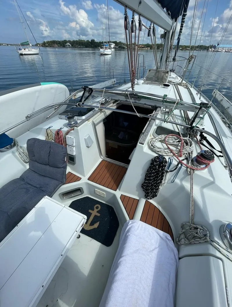 Slide: The Image of Beneteau M38 1990 sailboat cockpit with nautical equipment and serene water view. - 9