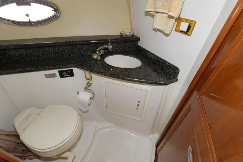 Slide: The Image of 2003 Carver 450 Voyager Pilothouse bathroom with sink, toilet, and granite countertop. - 13