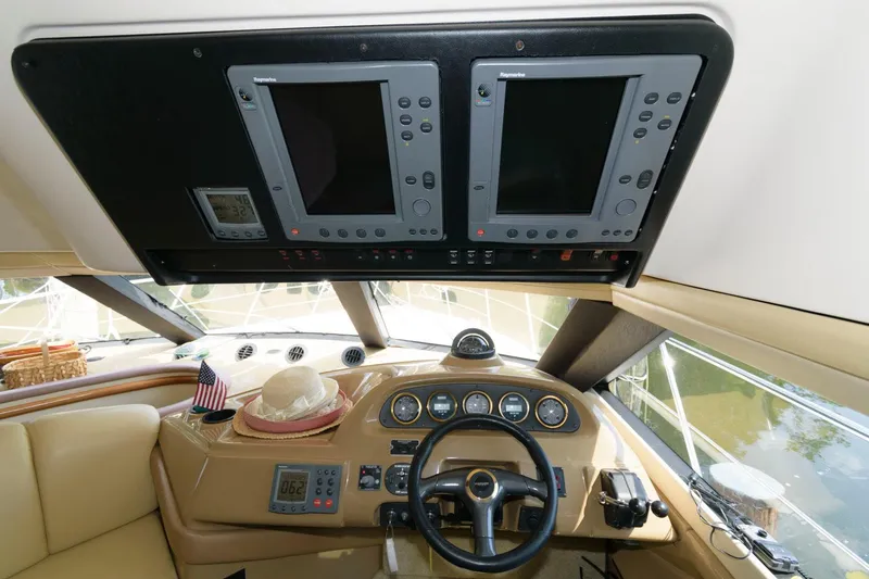 Slide: The Image of 2003 Carver 450 Voyager Pilothouse helm with dual navigation screens and steering wheel. - 4